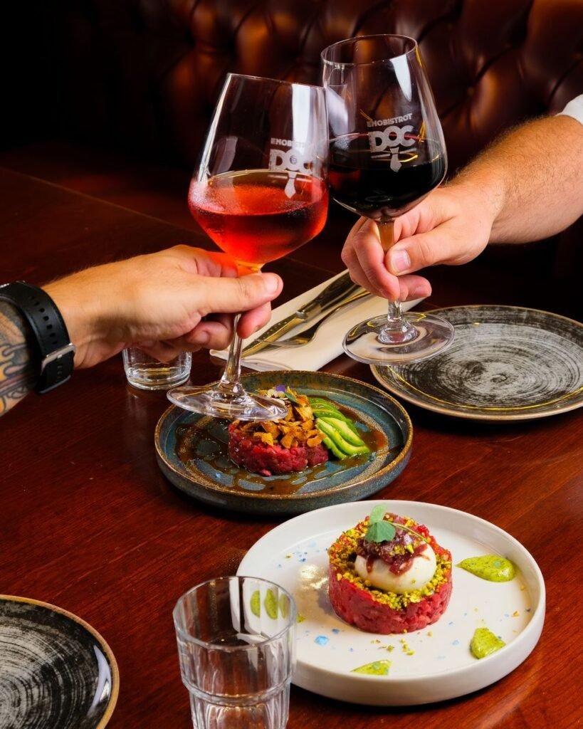 Brindis con copas de vino sobre los platos del bistró