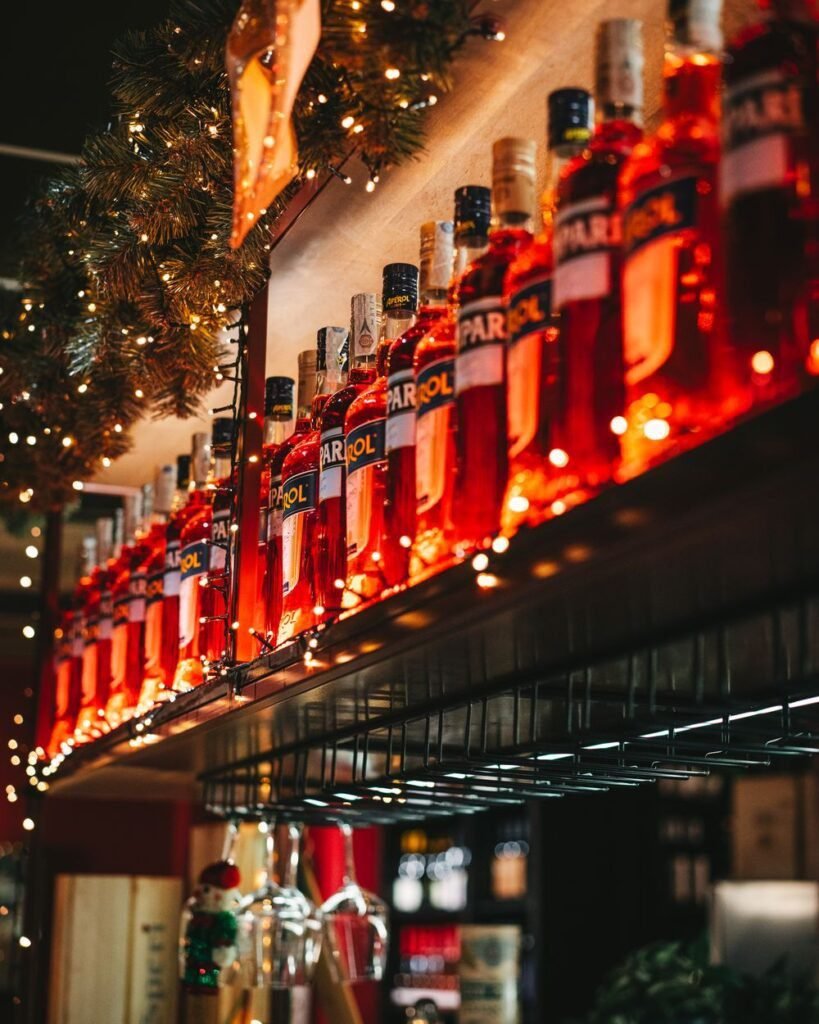 Barra de cócteles iluminada con botellas de aperitivos