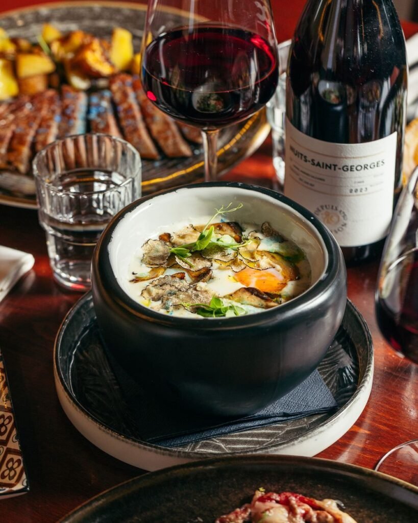 Huevo a 64 grados con carne en rodajas y vino tinto